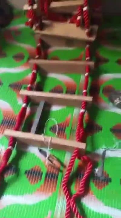 Hand assembly and knotting of heavy-duty rope ladder with wooden rungs in Karachi workshop