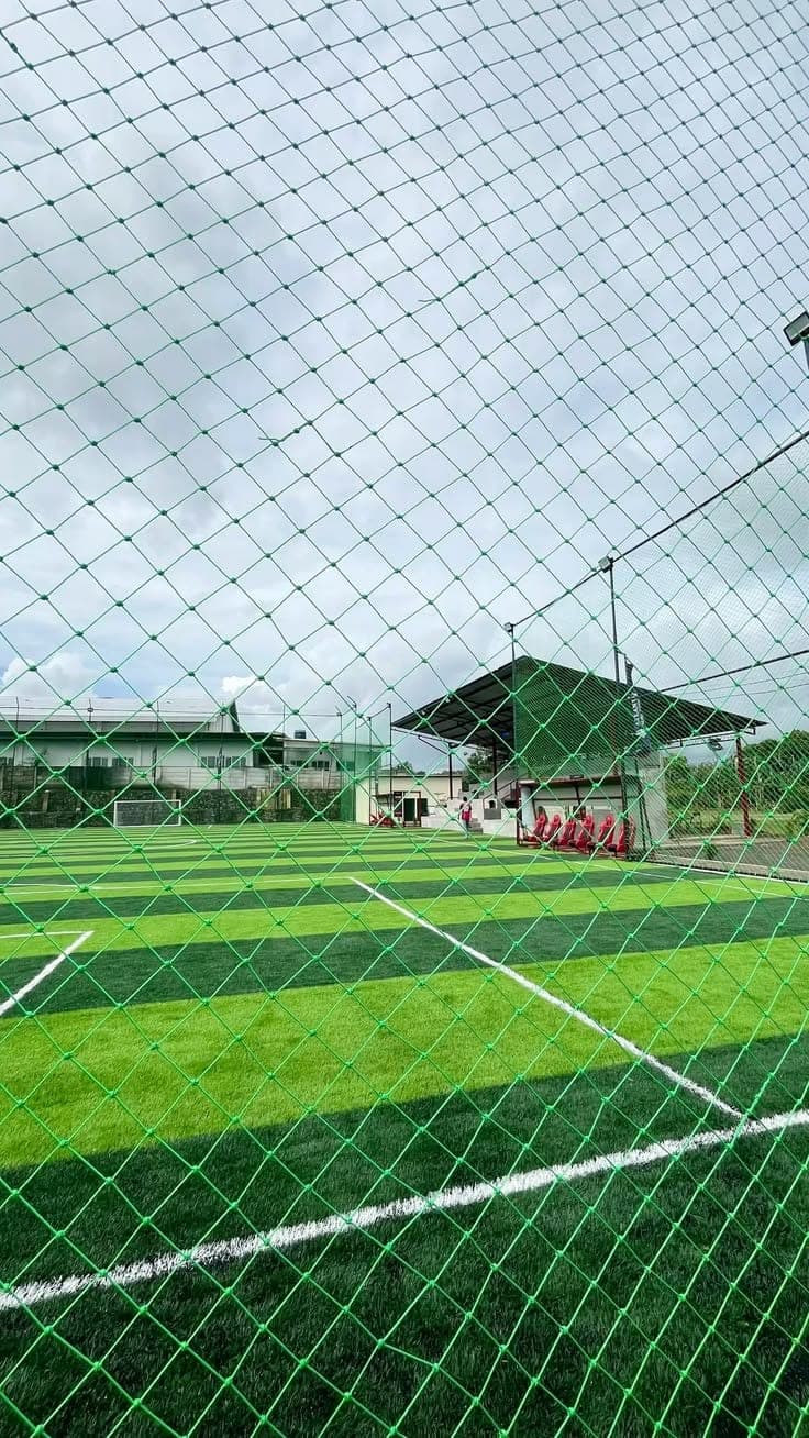 Green sports perimeter boundary netting enclosing football ground
