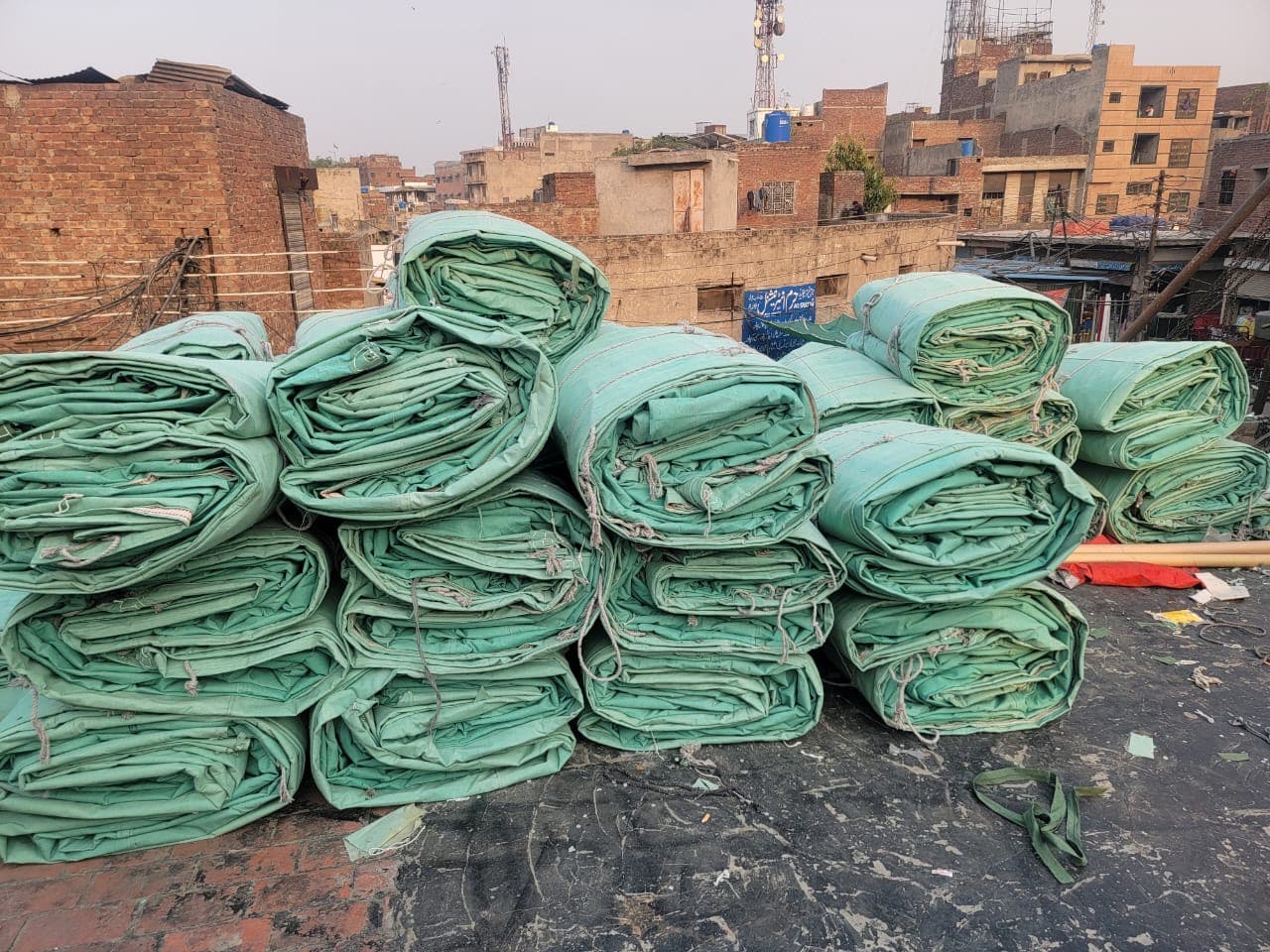 Folded green waterproof cotton canvas tarpaulin bundles ready for wholesale dispatch Karachi