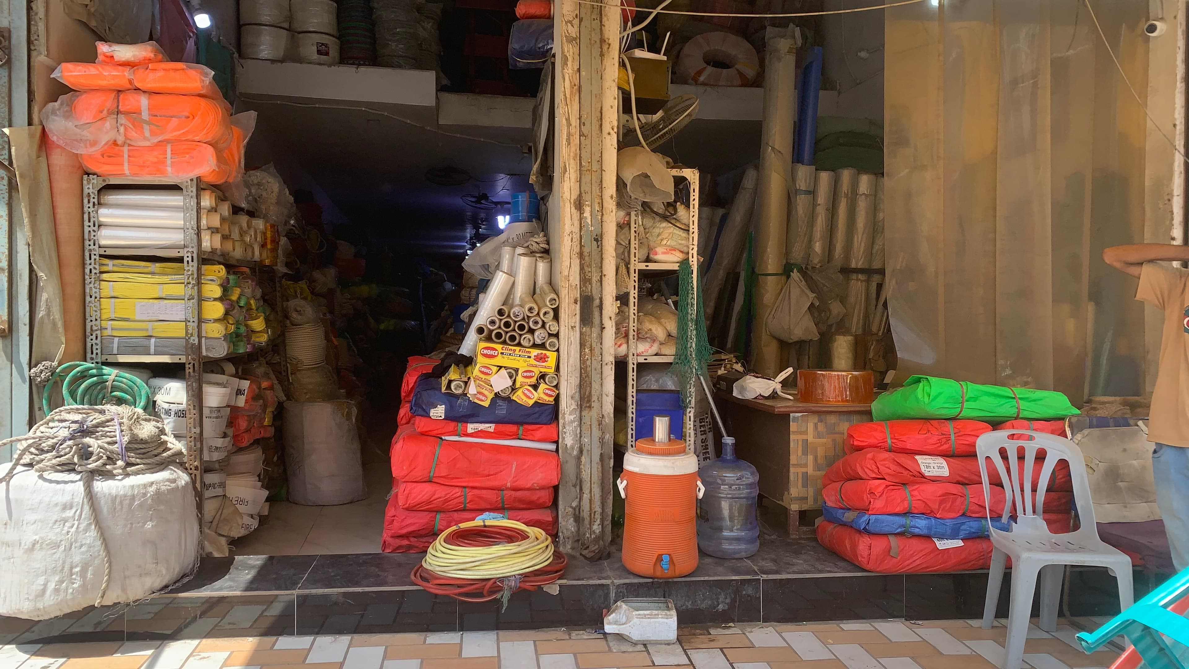 Tahira Syndicate wholesale shopfront counter on Shahra-e-Liaquat Road Karachi with ropes, lifting belts, suction pipes, and tarpaulins