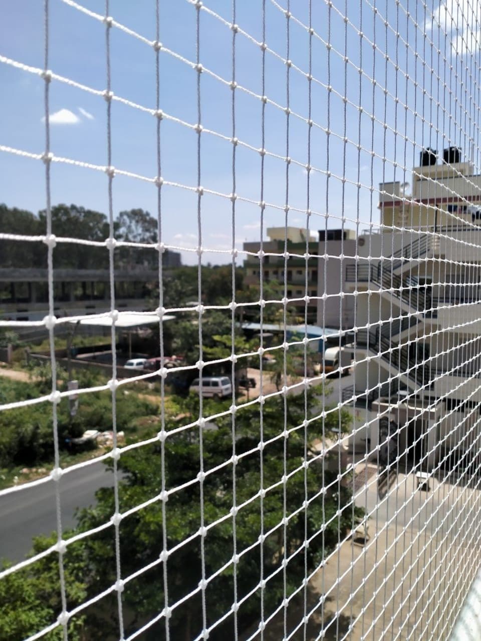 White anti-bird protective net installed on high-rise apartment balcony Karachi